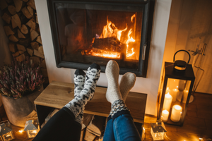 Two pairs of feet in front of the fire.png 0% loan to spread the cost of heating homes in North Devon